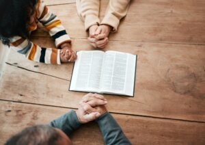 Bible, reading book or hands of grandma with children for worship, support or hope in Christianity