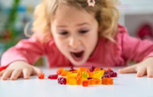 Child eating jelly candies at home. Selective focus.