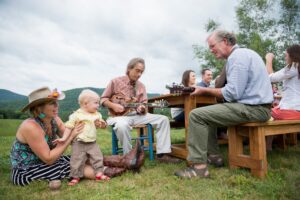 Two mature family members playing music at family meal, outdoors