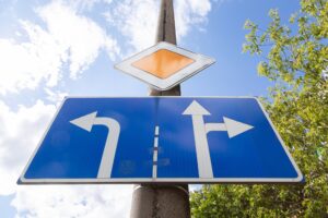 Bottom view of roadsign main road with tablet with direction allowed on crossroads against sky