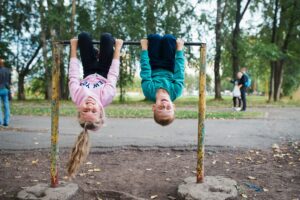 children hang upside down on the horizontal bar