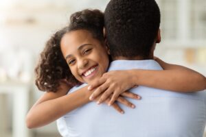 Happy black girl hugging her dad, closeup