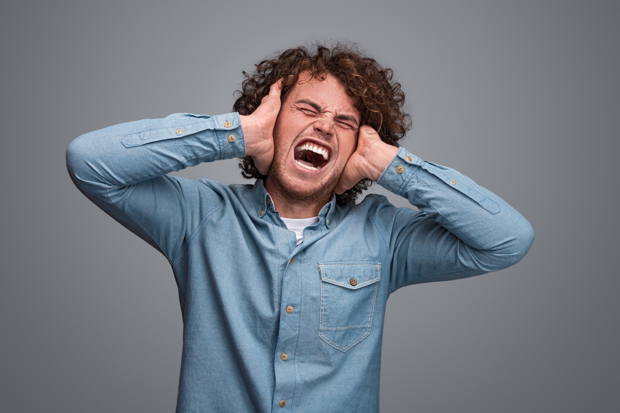 Man covering ears and screaming