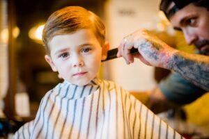 Barber combing boy's hair