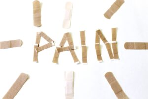 Overhead beige bandaids on a white background, pain