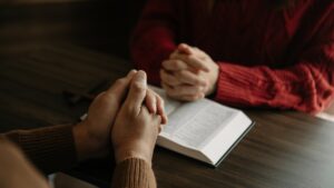 Two people reading and study bible in home and pray together.Studying the Word Of God With Friends.